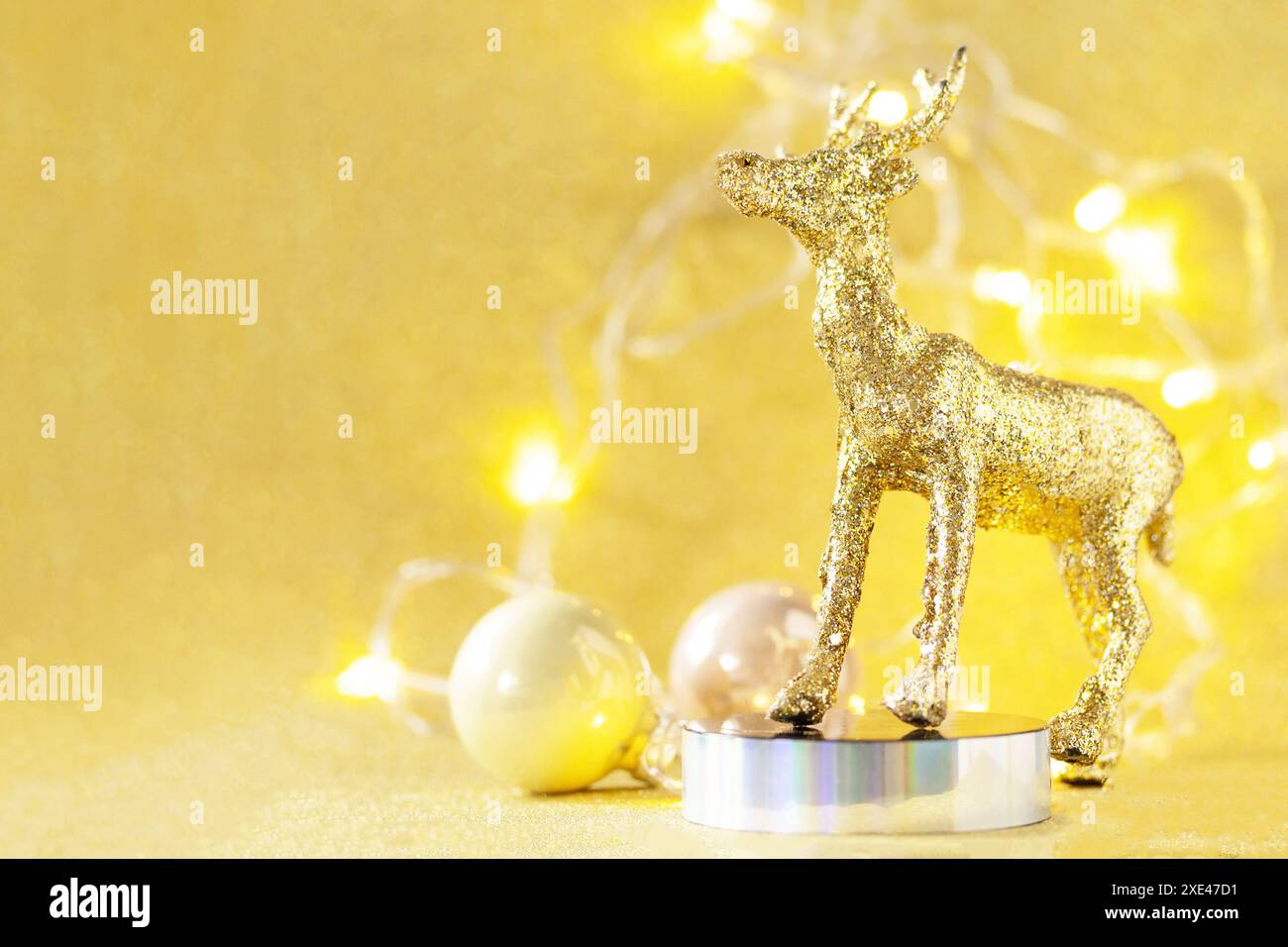 Magia del natale. Tavolozza di colori oro del cervo di Natale con decorazioni su sfondo dorato per il biglietto d'auguri. Spazio di copia. Foto Stock