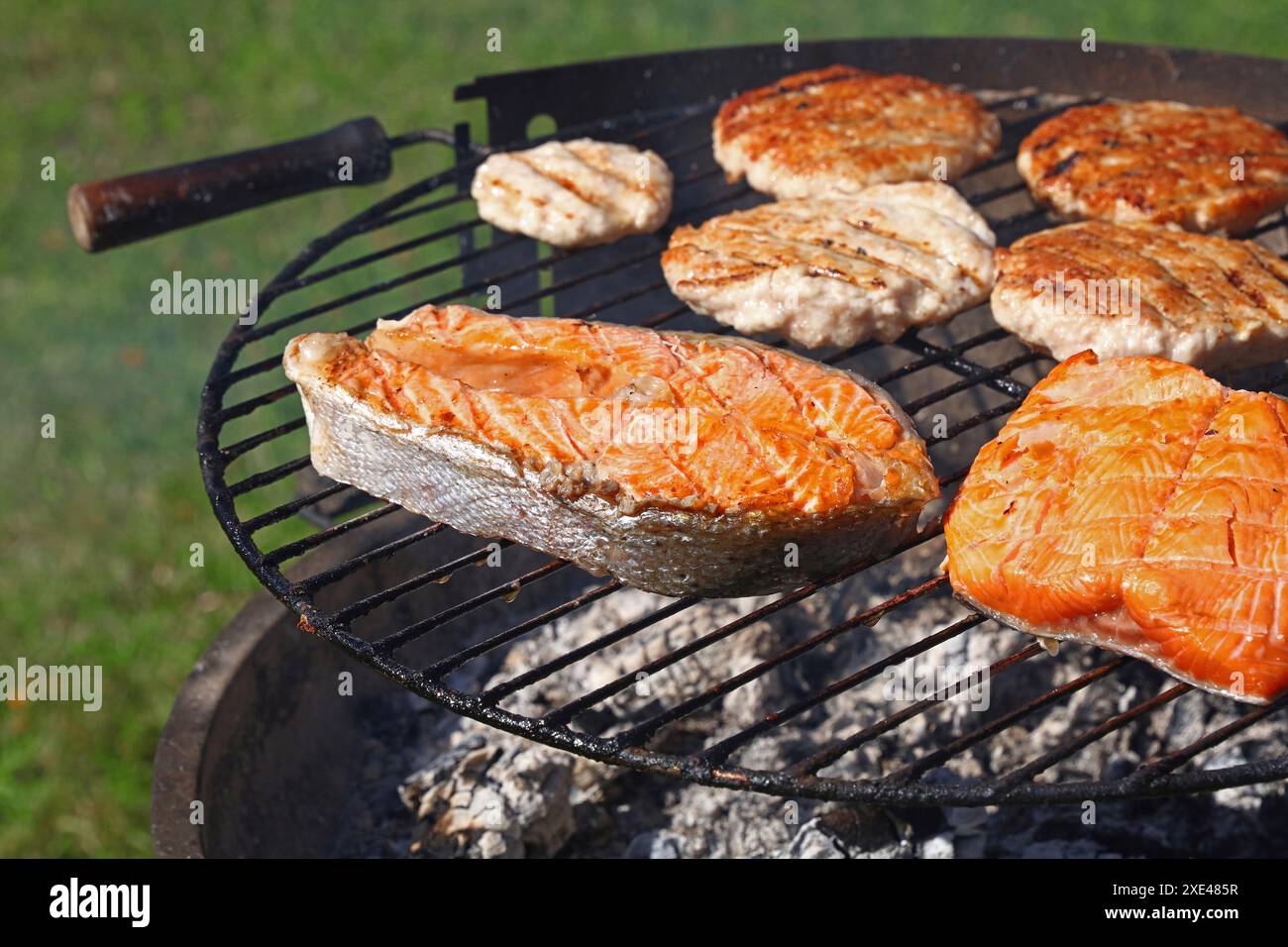 Hamburger di pollo o tacchino e bistecca di salmone alla griglia Foto Stock