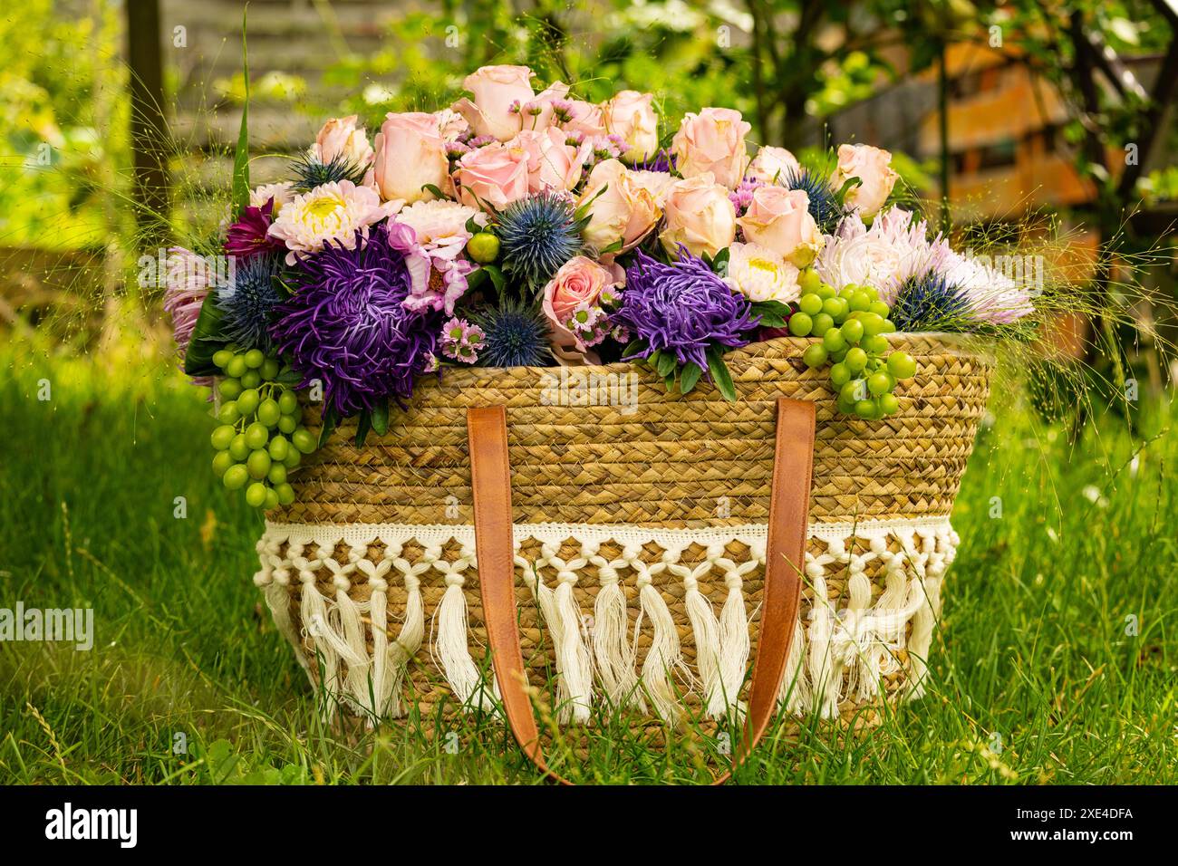 Bellissimo bouquet di fiori colorati con rose e altri fiori in un cestino Foto Stock