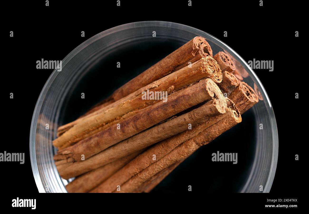 Cannella corteccia in un bicchiere dall'alto. Bastoncini di corteccia cruda di Ceylon e cannella indonesiana, Cinnamomum verum e C. burmanni. Foto Stock
