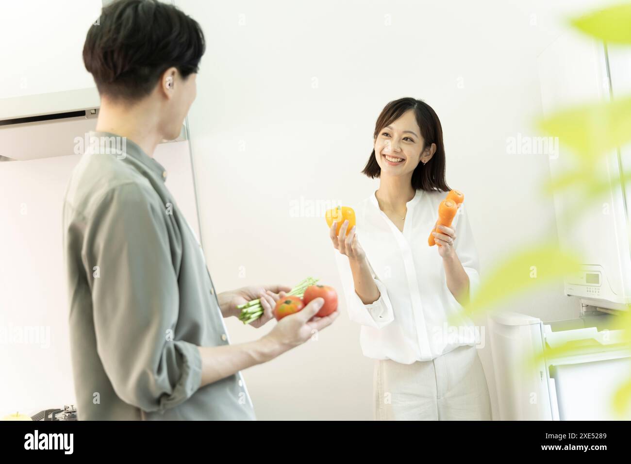 Una coppia di 30 anni sorridente l'un l'altra in cucina Foto Stock