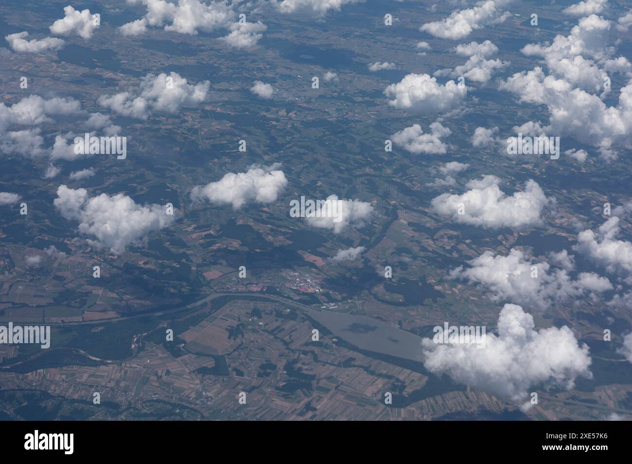 Il cielo è pieno di nuvole e la terra sottostante di fiume. le nuvole sono sparse in tutto il cielo, con alcune più grandi e più prominenti di altre. TH Foto Stock