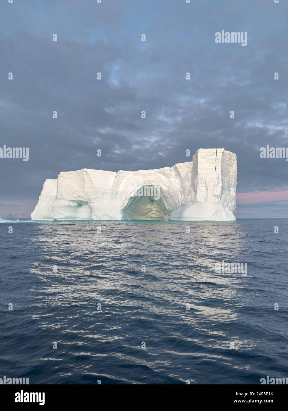 Un enorme ghiacciaio distaccato si getta nell'oceano meridionale al largo della costa dell'Antartide al tramonto, la penisola Antartica, la S Foto Stock Un enorme ghiacciaio distaccato si getta nell'oceano meridionale al largo della costa dell'Antartide al tramonto, la penisola Antartica, la S Foto Stock