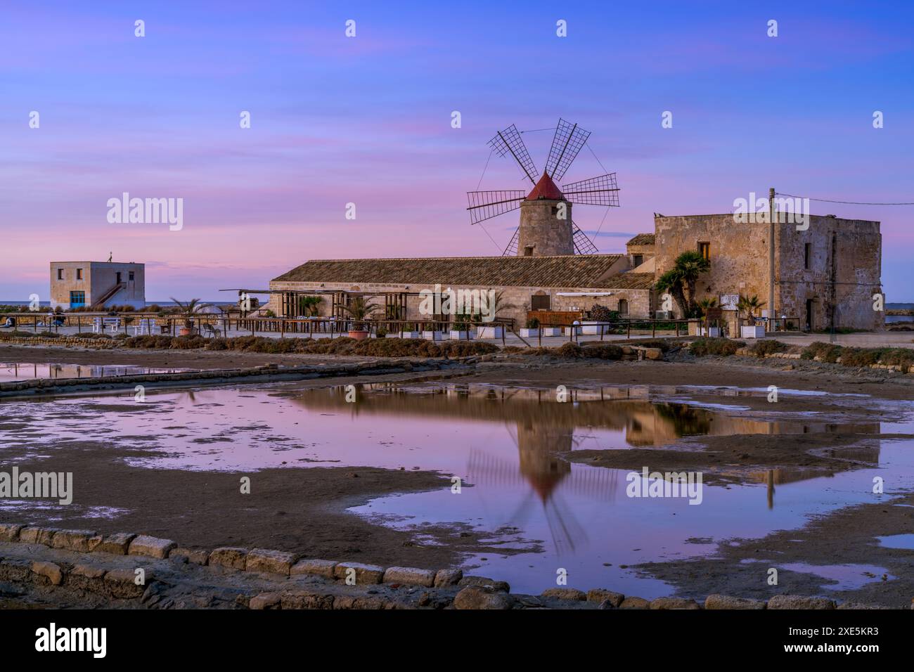Vista del mulino a vento e del museo di sale di Paceco al tramonto Foto Stock