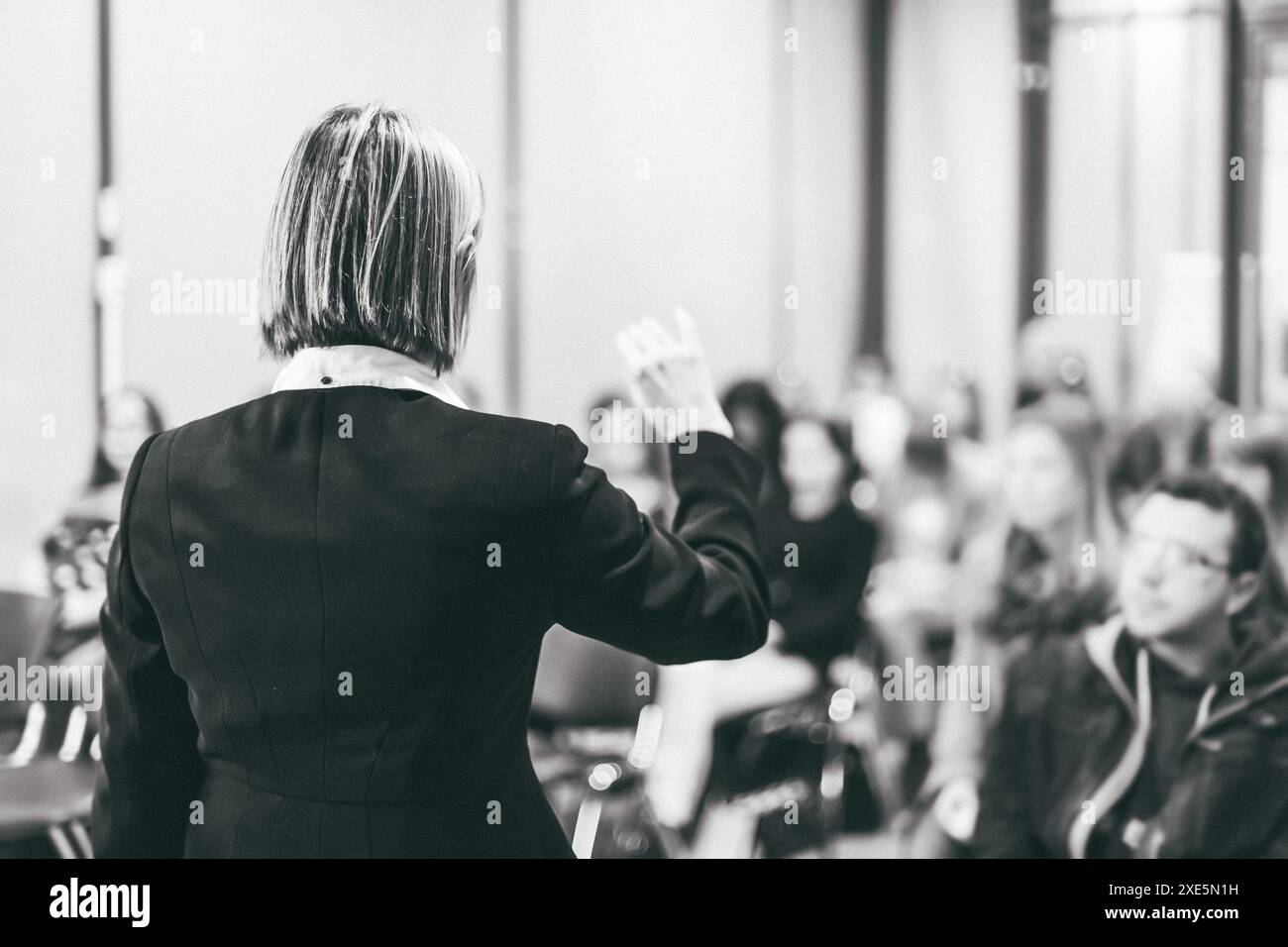 Altoparlante femmina dando un talk sulla corporate business conference. Irriconoscibile la gente in pubblico in sala conferenza. Business e imprenditorialità eve Foto Stock