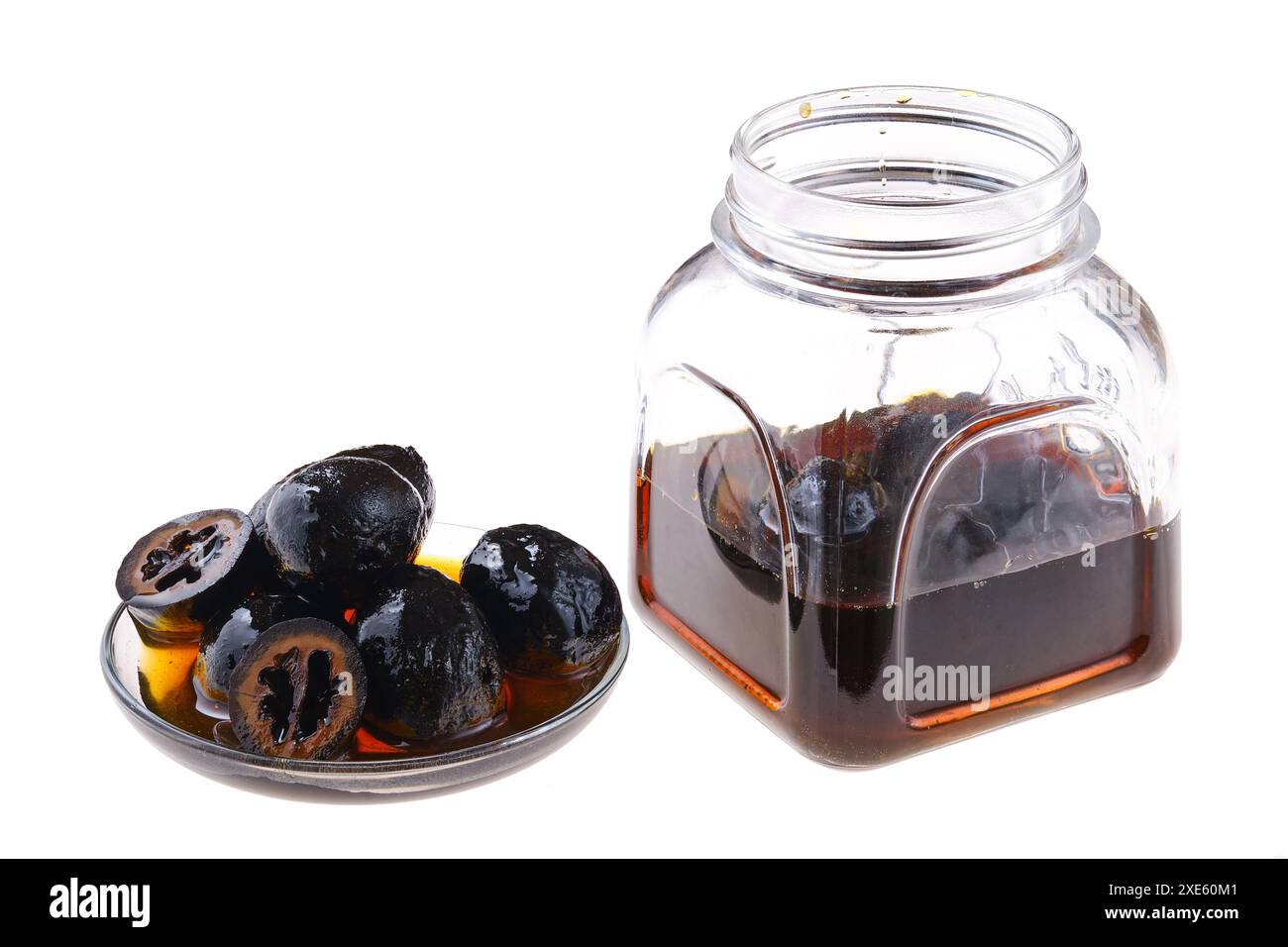 Piattino e vaso con noci conservate fatte in casa isolate su bianco Foto Stock