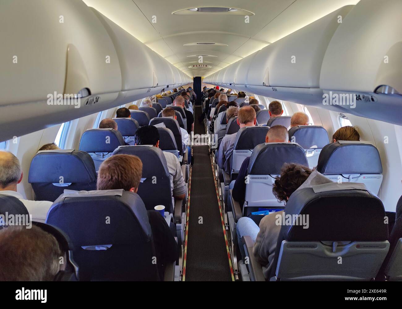 Passeggeri all'interno di un aeromobile durante una dimostrazione di sicurezza da parte degli assistenti di volo Foto Stock