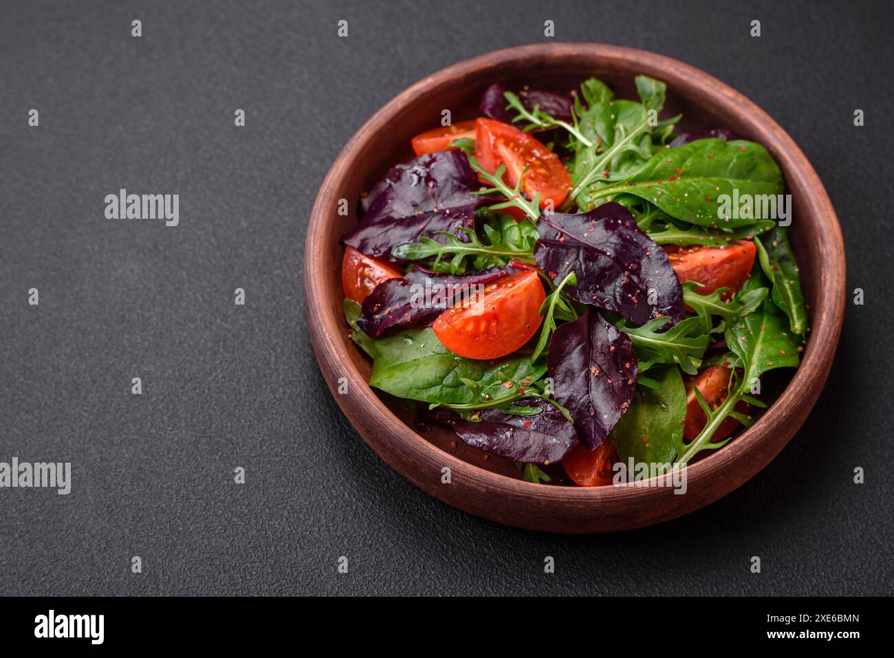 Insalata di pomodori ciliegini freschi, rucola, spinaci e foglie giovani di barbabietola Foto Stock