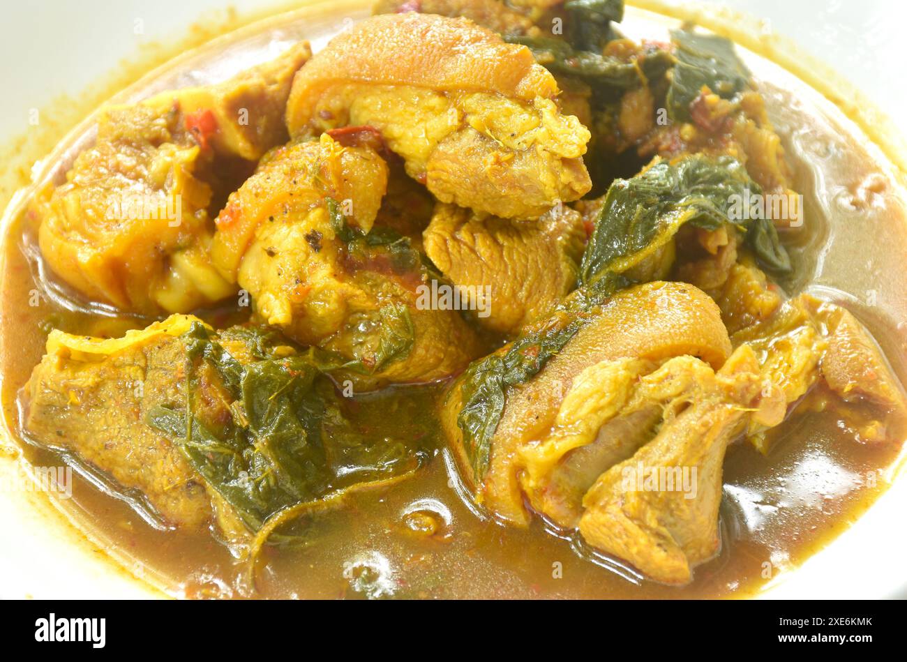 coscia di maiale piccante bollita con cumino e basilico in zuppa di curry al latte di cocco sul piatto Foto Stock