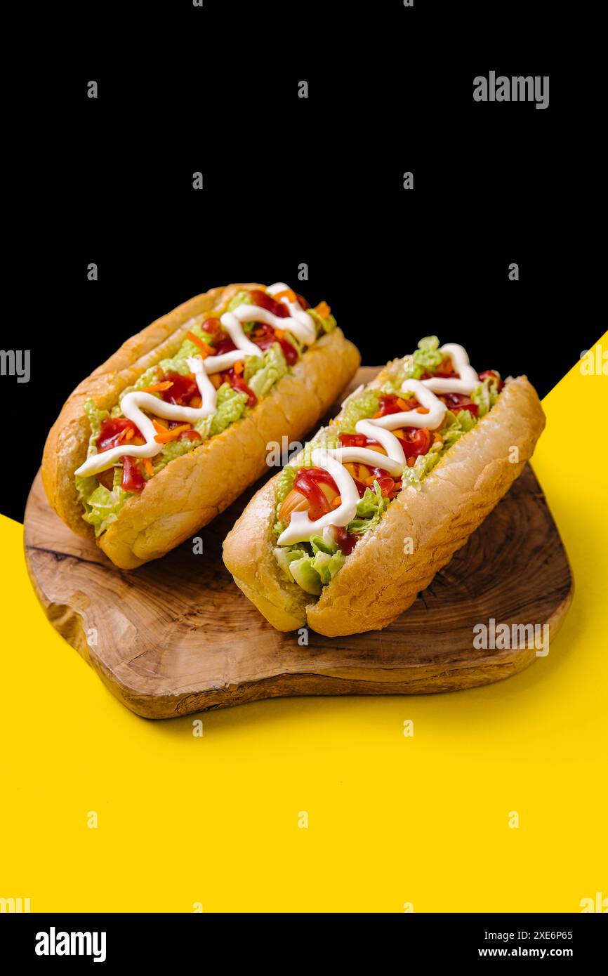 Due deliziosi hotdog su una tavola di legno Foto Stock