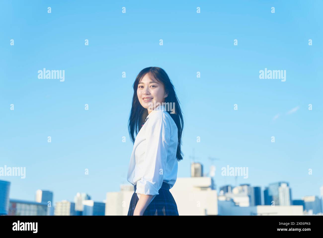Studente in camicia che ci guarda sul tetto Foto Stock