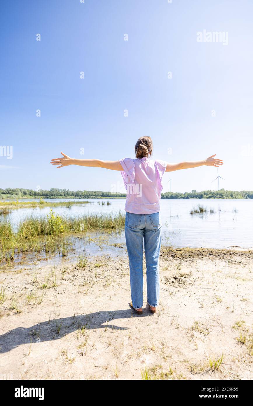 Donna con braccia allungate che abbraccia la natura Foto Stock