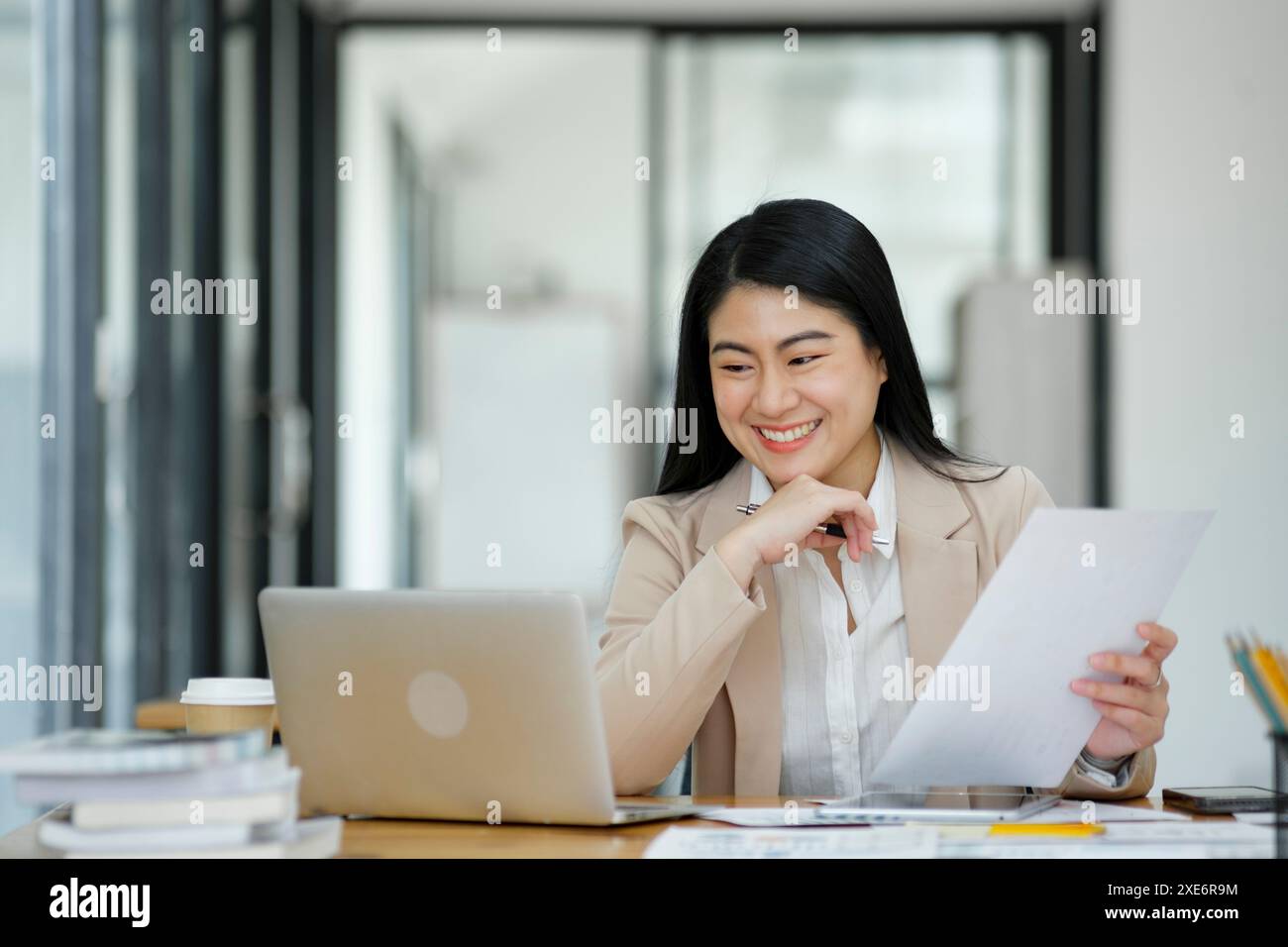 Donna d'affari che analizza i dati su un notebook in ufficio. Foto Stock