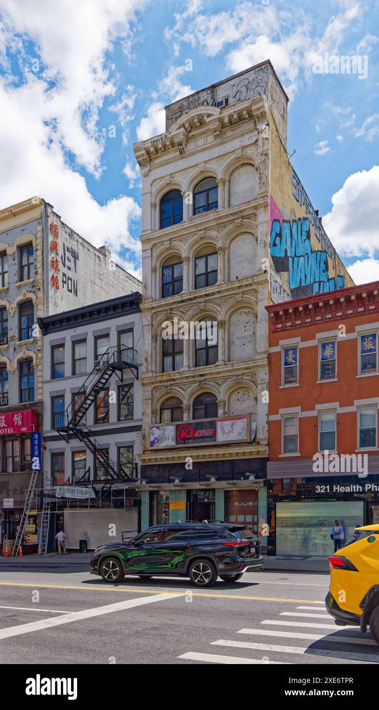Chinatown di New York: 97 Bowery, un edificio loft in ghisa di New York, è in rovina, addossato di graffiti e vernice bianca sbiadita. Foto Stock