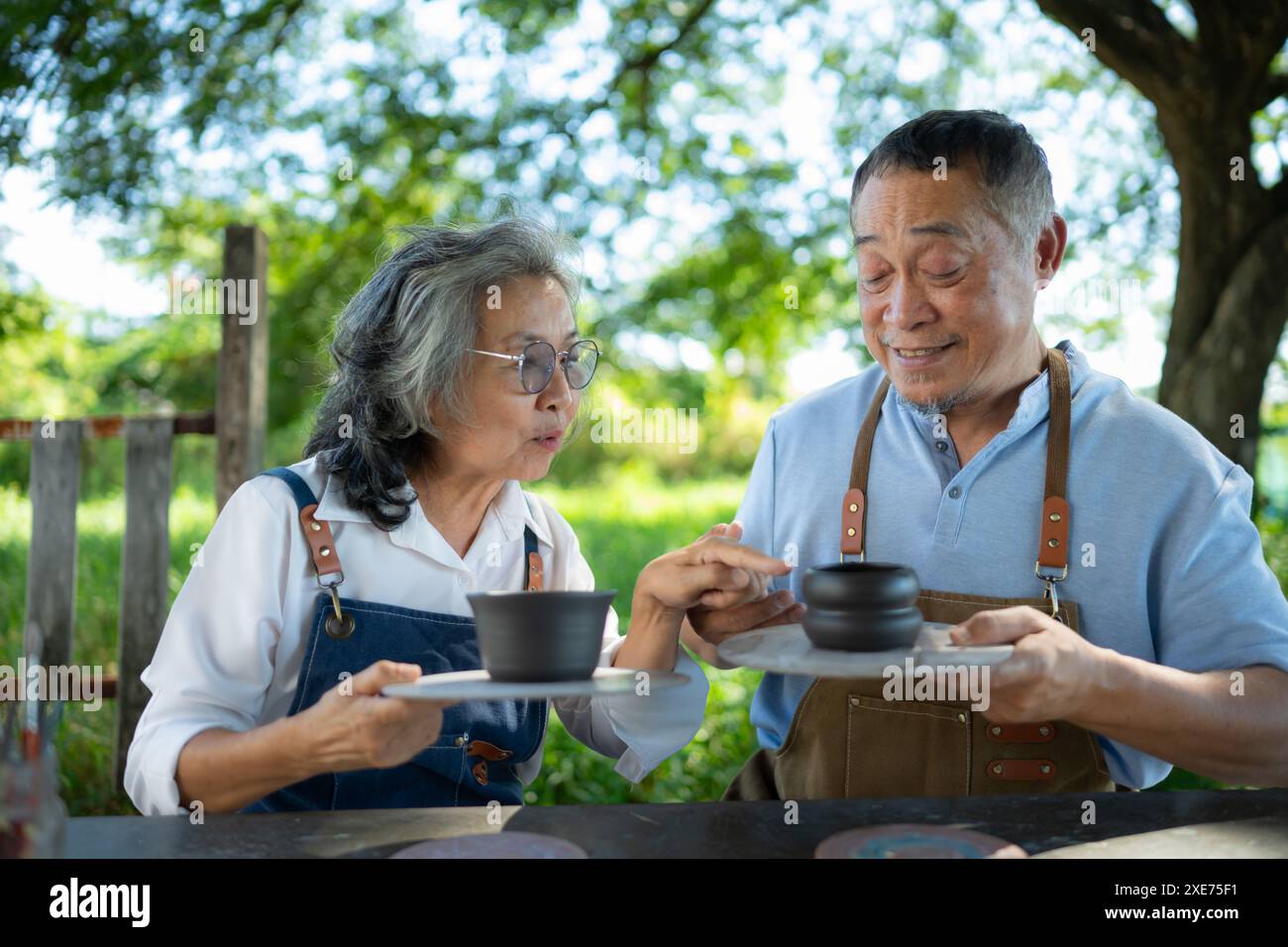 Nel laboratorio di ceramica, una coppia asiatica in pensione è impegnata nella produzione di ceramiche e nella pittura di argilla. Foto Stock