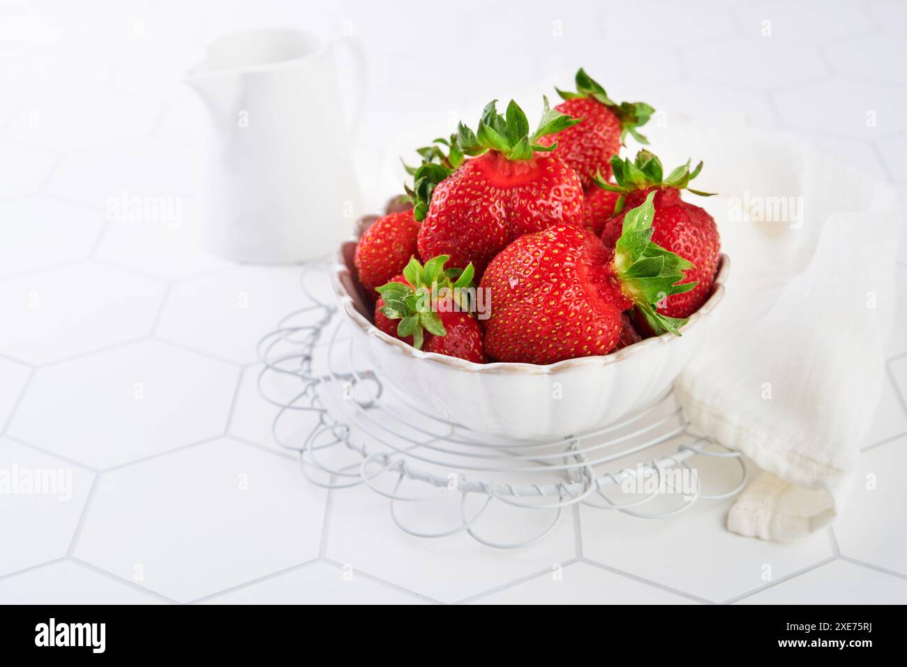 Fragole cotte in casa con ciambella biologica e panna su fondo bianco in legno. Concetto di prodotti ecologici biologici locali e natura riserva Foto Stock