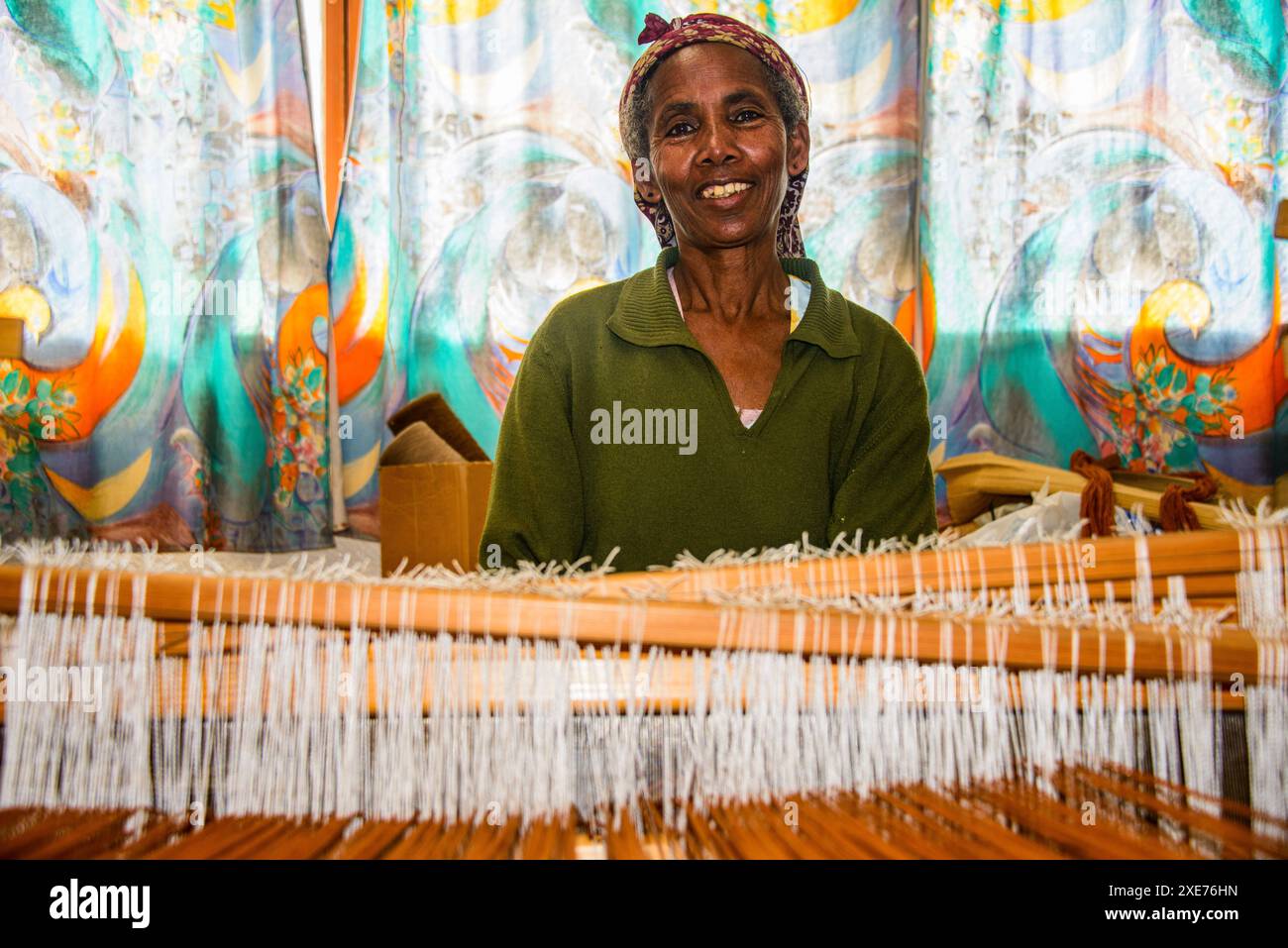 Donna gentile lavorando su un lato del telaio di tessitura su un progetto sociale nelle Highlands di Eritrea, Africa Foto Stock