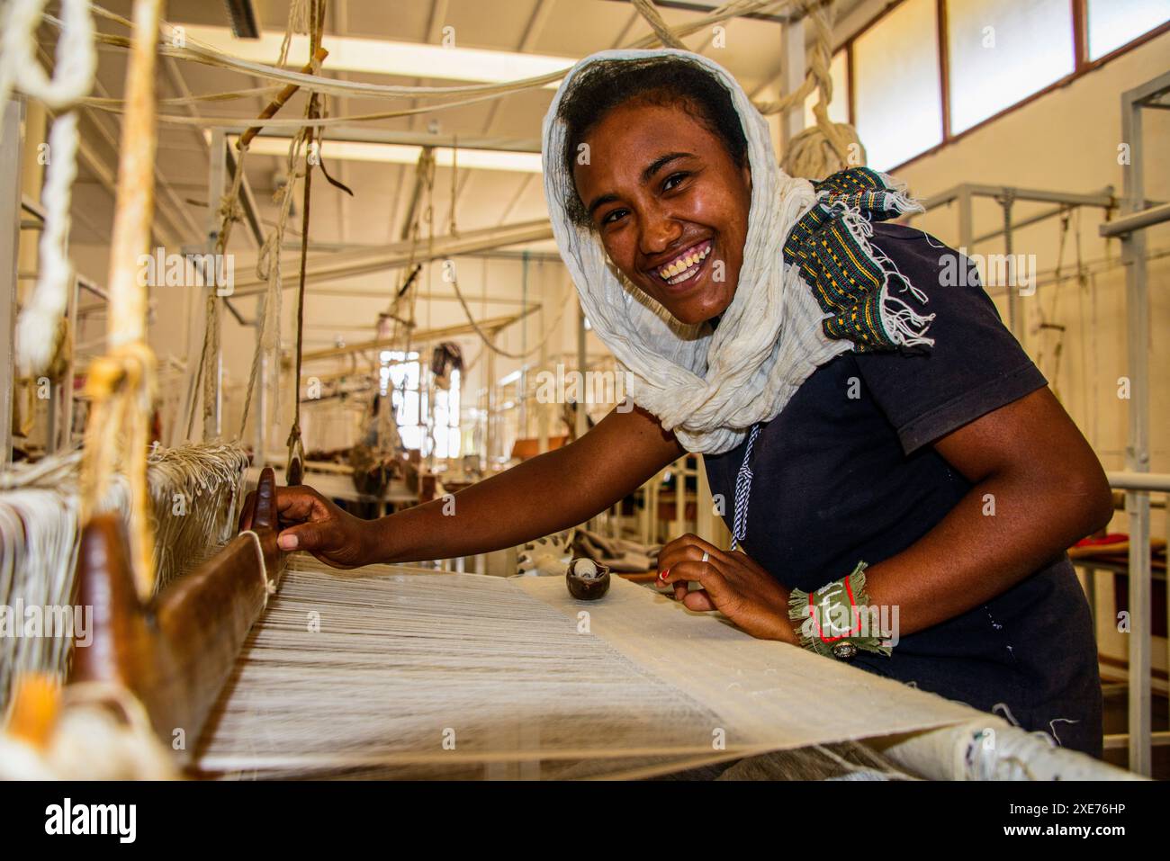 Donna gentile lavorando su un lato del telaio di tessitura su un progetto sociale nelle Highlands di Eritrea, Africa Foto Stock
