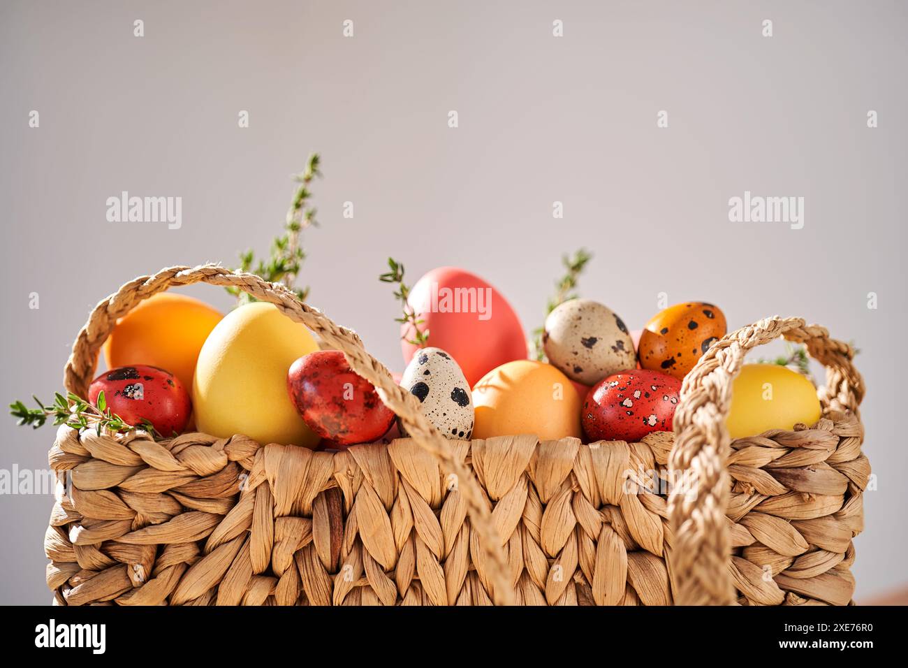 Uova di Pasqua in un sacchetto di vimini. Composizione pasquale. Foto Stock