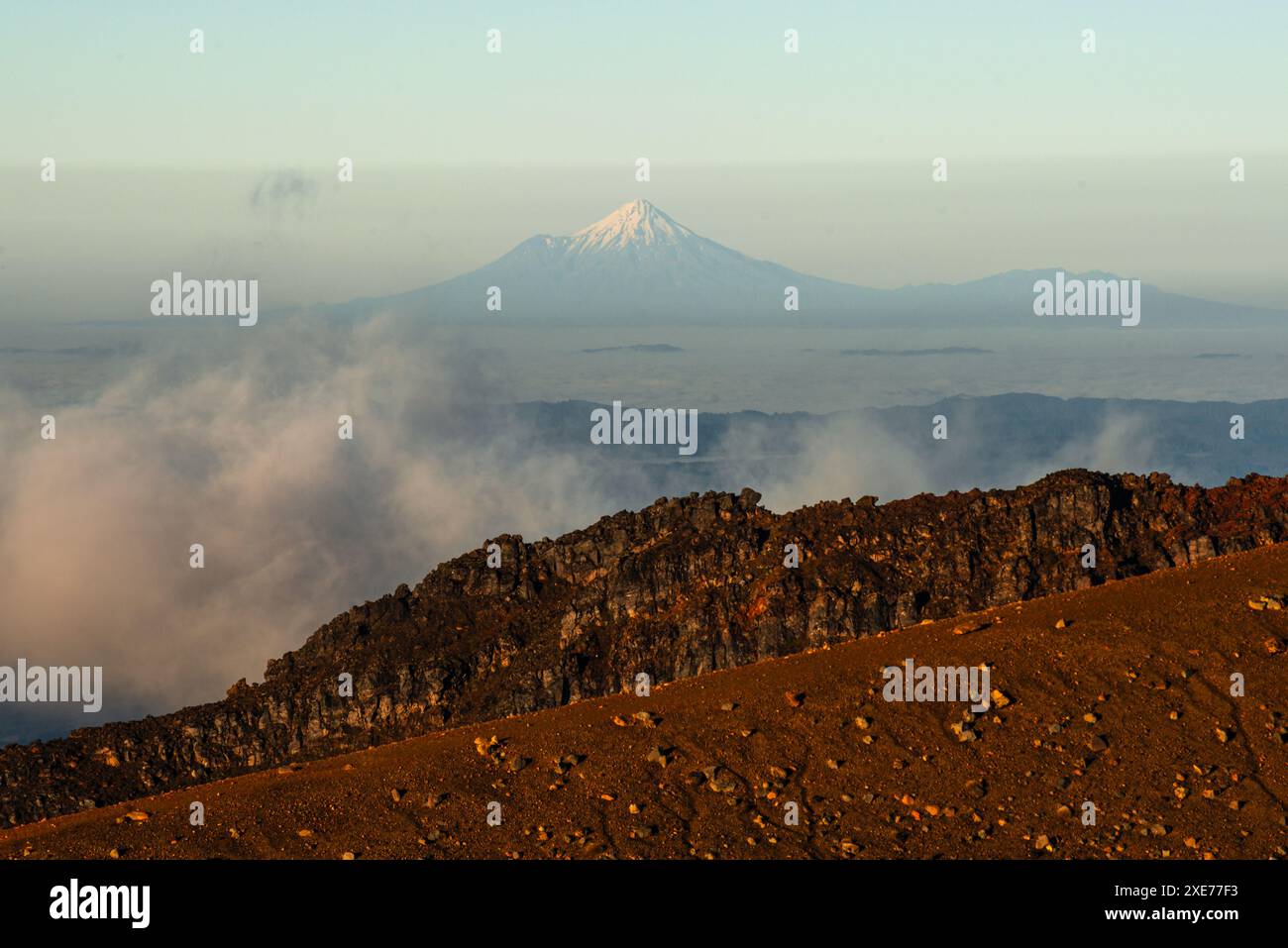 Vista del paesaggio vulcanico del lontano vulcano Taranaki, vista dal Parco Nazionale di Tongariro, sito Patrimonio dell'Umanità dell'UNESCO, Isola del Nord, nuova Zelanda Foto Stock