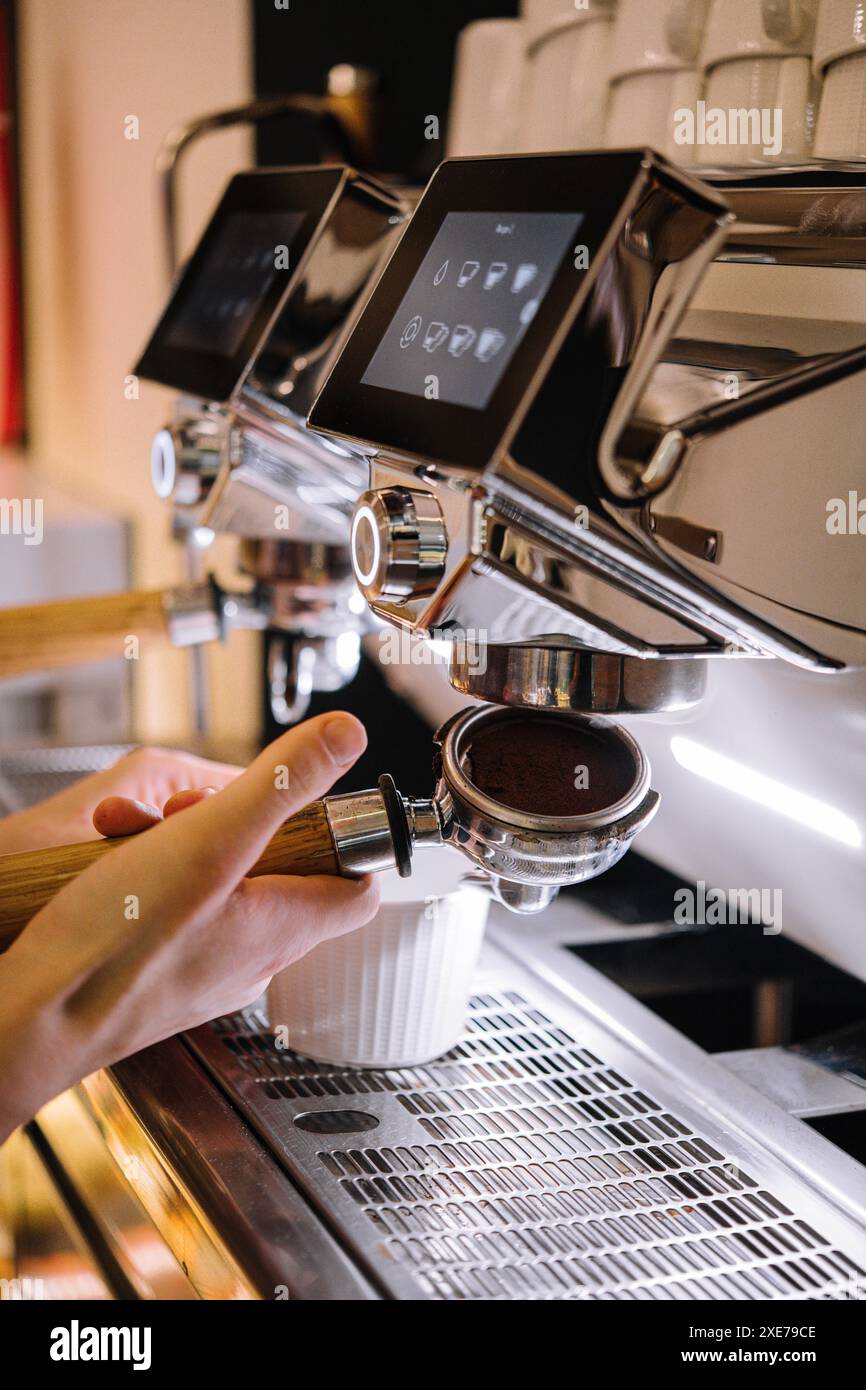 Barista fa caffè in una macchina per il caffè Foto Stock