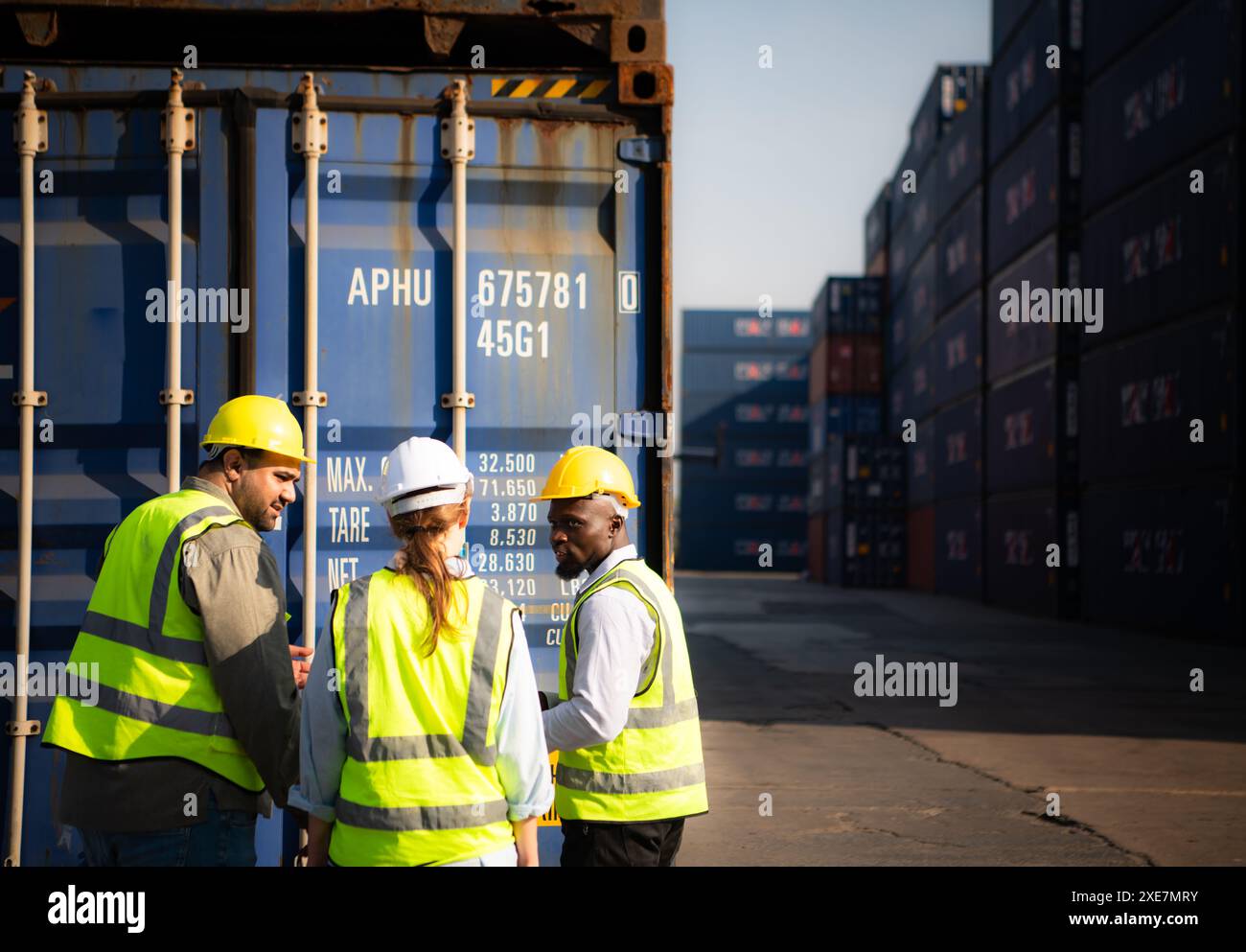 Gruppo di lavoratori in un deposito di contenitori vuoto, la condizione del vecchio contenitore è in corso di valutazione per determinare se io Foto Stock