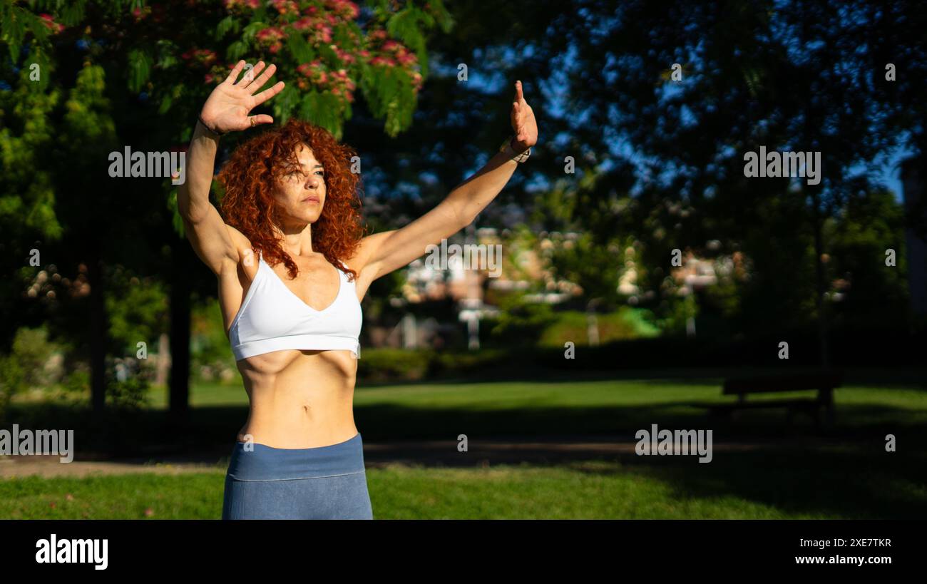 Donna messicana di mezza età che esegue esercizi ipopressivi all'aperto con spazio di copia Foto Stock