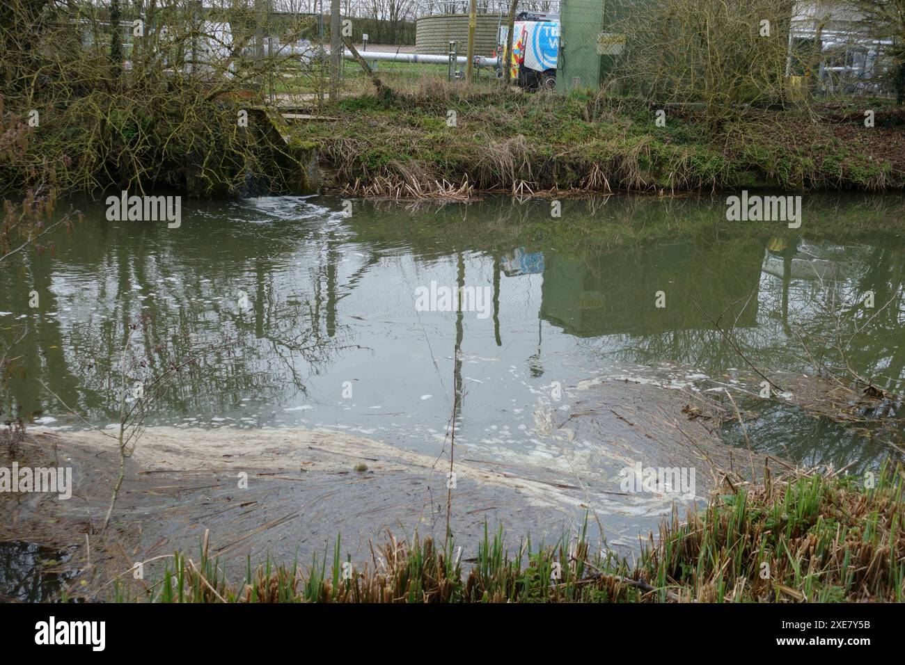 Il tubo di troppopieno delle acque reflue da un impianto di trattamento sul canale Kennet e Avon a Kintbury con un accumulo di scorie e inquinamento sulla riva opposta Foto Stock