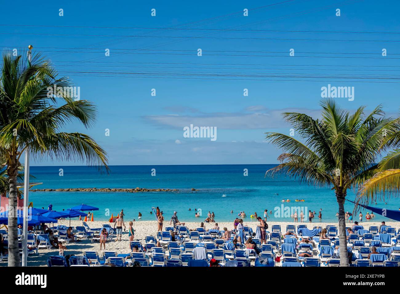 Caribbean Sun Retreat: I vacanzieri si divertono nella serenità, prendendo il sole sulle spiagge tropicali di Great Stirrup Cay Foto Stock