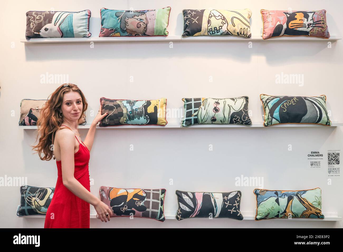 Londra, Regno Unito. 26 giugno 2024. Emma Chalmers della Heriot-Watt University con i suoi disegni di cuscini. I laureati espongono le loro creazioni alla mostra New Designers Design presso il Business Design Centre. L'evento si svolge nell'arco di due settimane, mettendo in evidenza nuovi talenti nel campo della moda, del tessile, dell'arredamento, del design dei prodotti, dell'illustrazione, e molto altro ancora. Crediti: Imageplotter/Alamy Live News Foto Stock