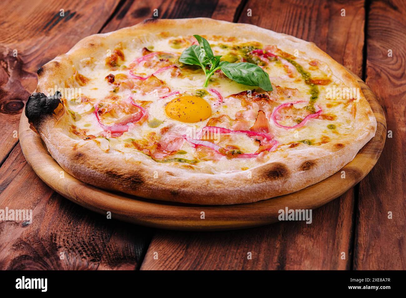 Pizza italiana con tuorlo d'uovo, prosciutto e cipolla Foto Stock
