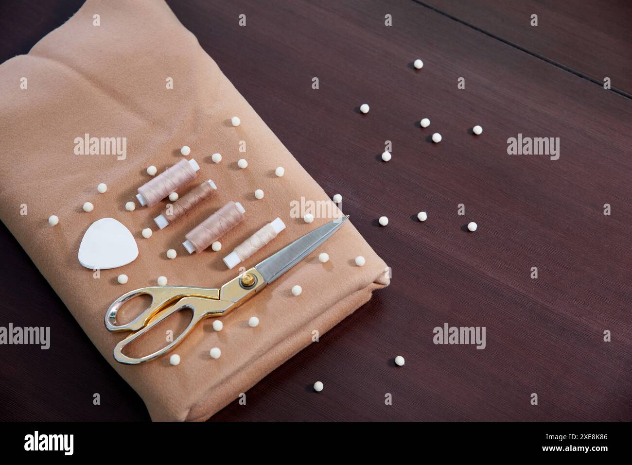 Gruppo di oggetti da cucire distesi su un tavolo di legno, concetto di sartoria Foto Stock