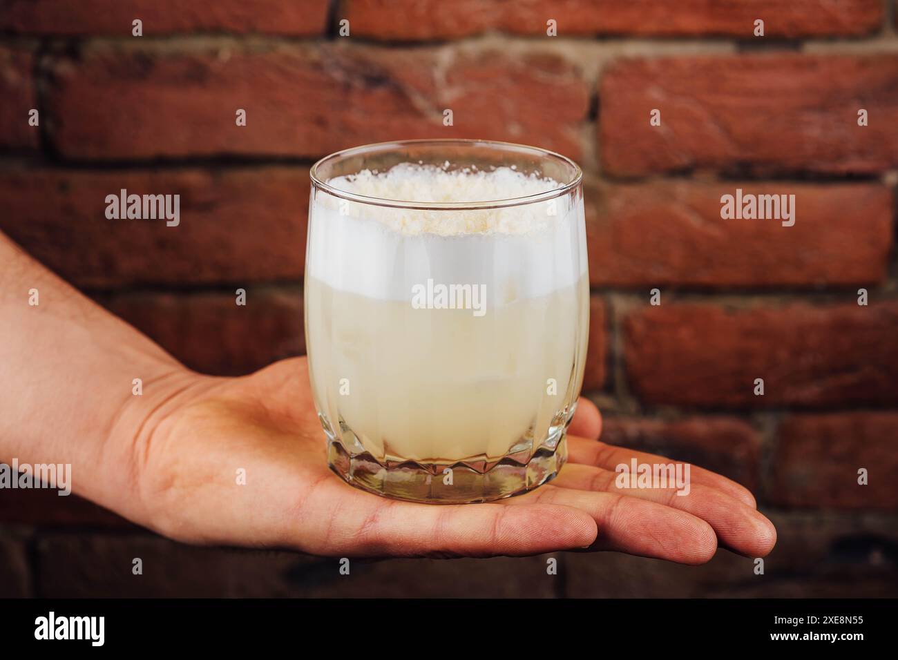 Cocktail con lime e schiuma bianca in un bicchiere di vetro Foto Stock