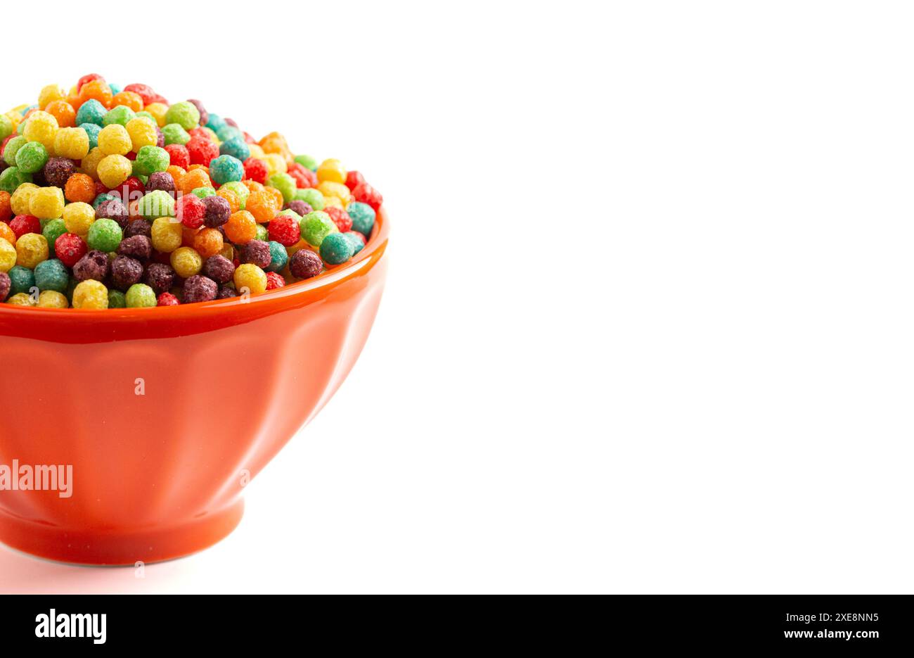 Piccola palla arcobaleno aromatizzata alla frutta per la colazione, con cereali isolati su sfondo bianco Foto Stock