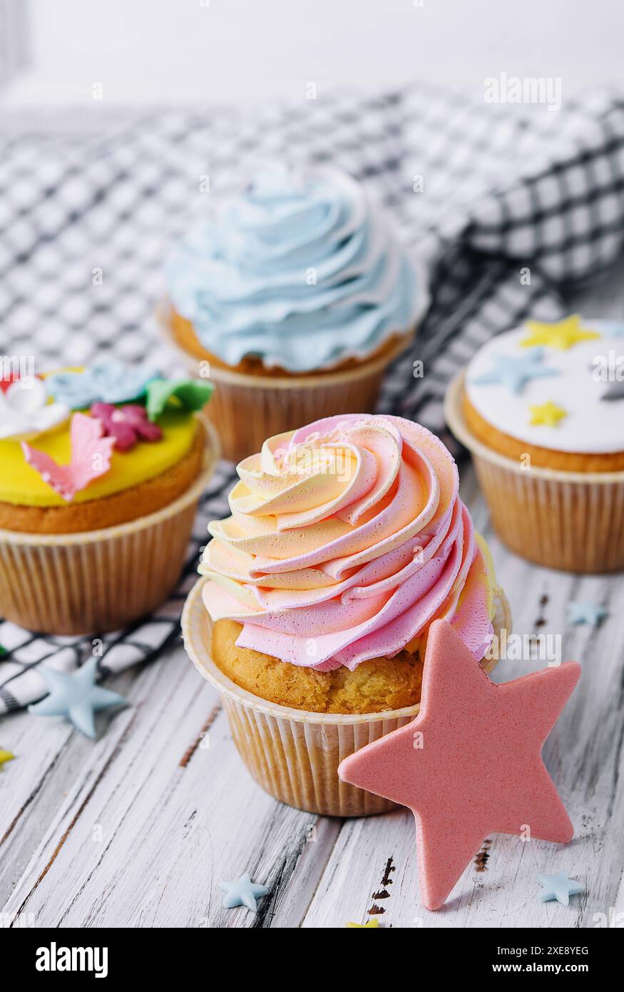 Numerosi muffin colorati e ben decorati su sfondo in legno Foto Stock