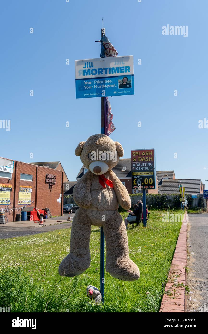 Hartlepool, Cleveland, Regno Unito. 26 giugno 2024. Hartlepool, dove i candidati alle elezioni generali del 2024 includono Jill Mortimer (con) e Jonathan Brash (Lab). Nelle elezioni locali di maggio in città, i laburisti ottennero tutti gli 8 seggi del consiglio da con (6) e Ind (2). Nella foto: Mostra di un orsacchiotto e di un tabellone elettorale conservatore in un autolavaggio. Crediti: Hazel Plater/Alamy Live News Foto Stock