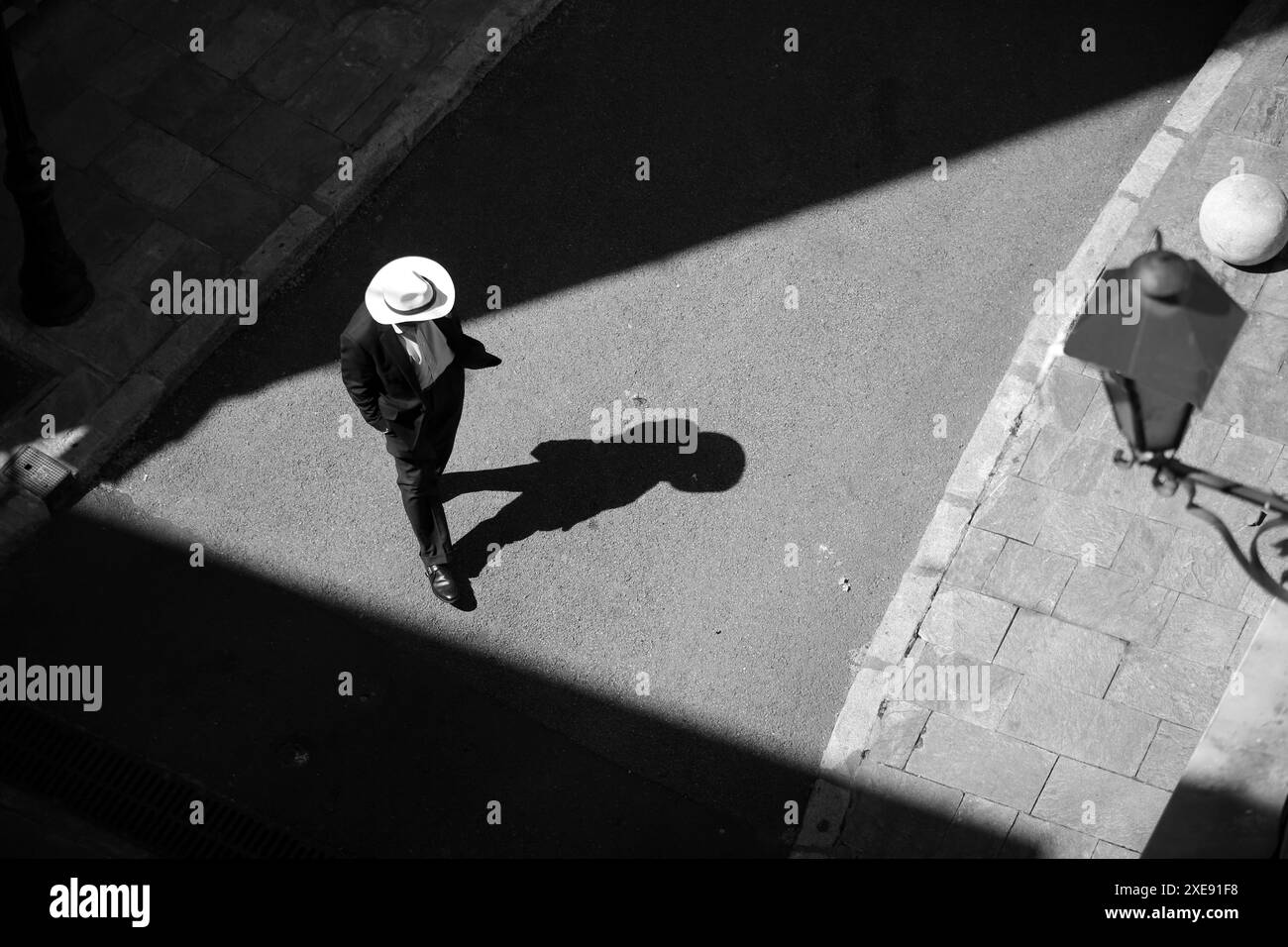 Uomo con cappello bianco che attraversa la strada dall'alto. Grasse, Alpes Maritimes, PACA, Costa Azzurra, Francia Foto Stock