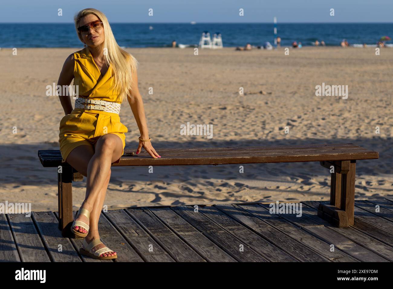 Questa immagine cattura una donna con un trucco delicato, capelli biondi ben modellati e occhi marroni caldi. Foto Stock