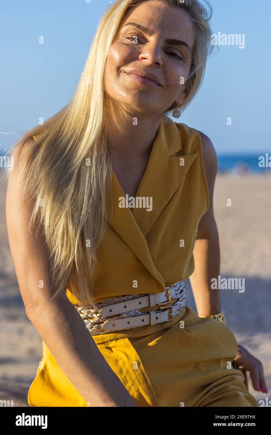 Questa immagine cattura una donna con un trucco delicato, capelli biondi ben modellati e occhi marroni caldi. Foto Stock