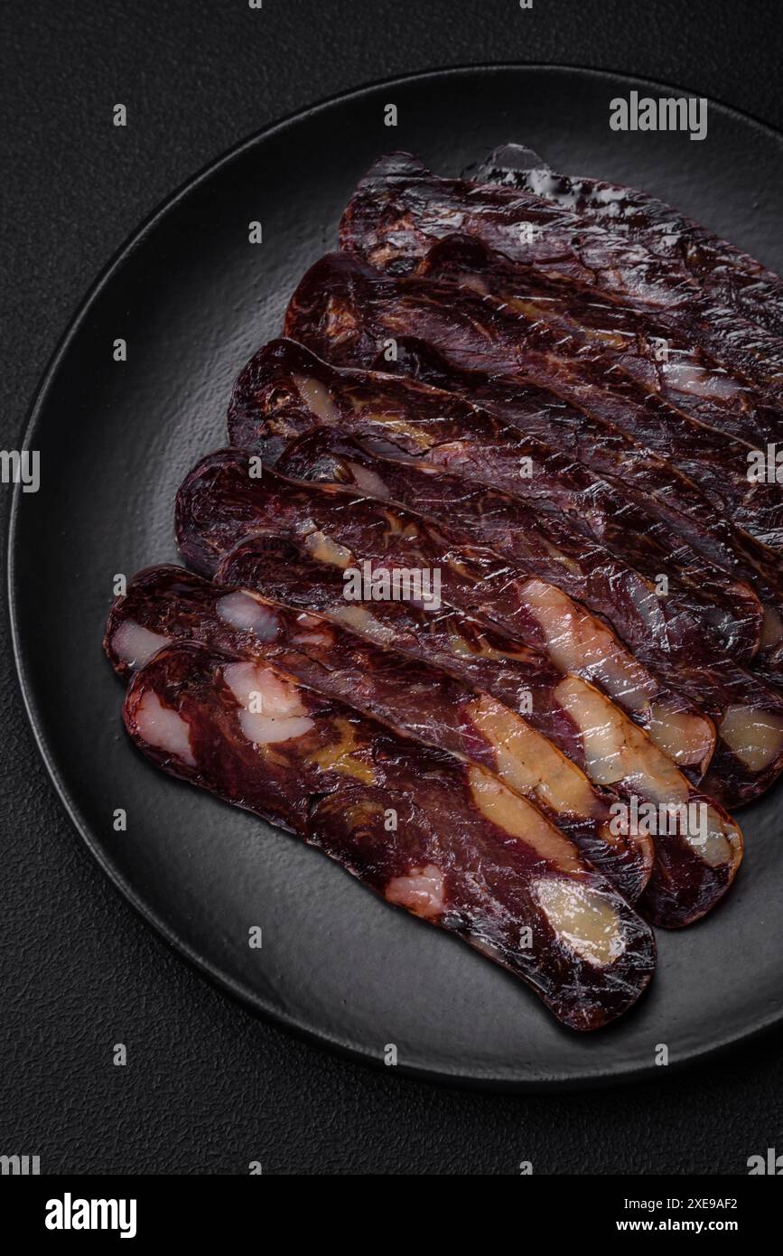 Deliziosa salsiccia di carne di cavallo mahan affumicata o curata con spezie ed erbe su fondo di cemento scuro Foto Stock