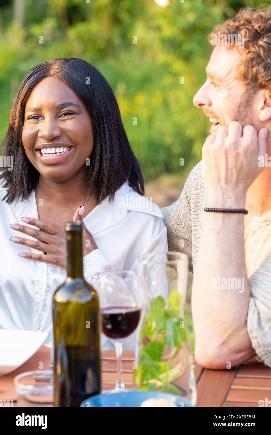 Risate e gioia in una serata informale all'aperto con vino Foto Stock