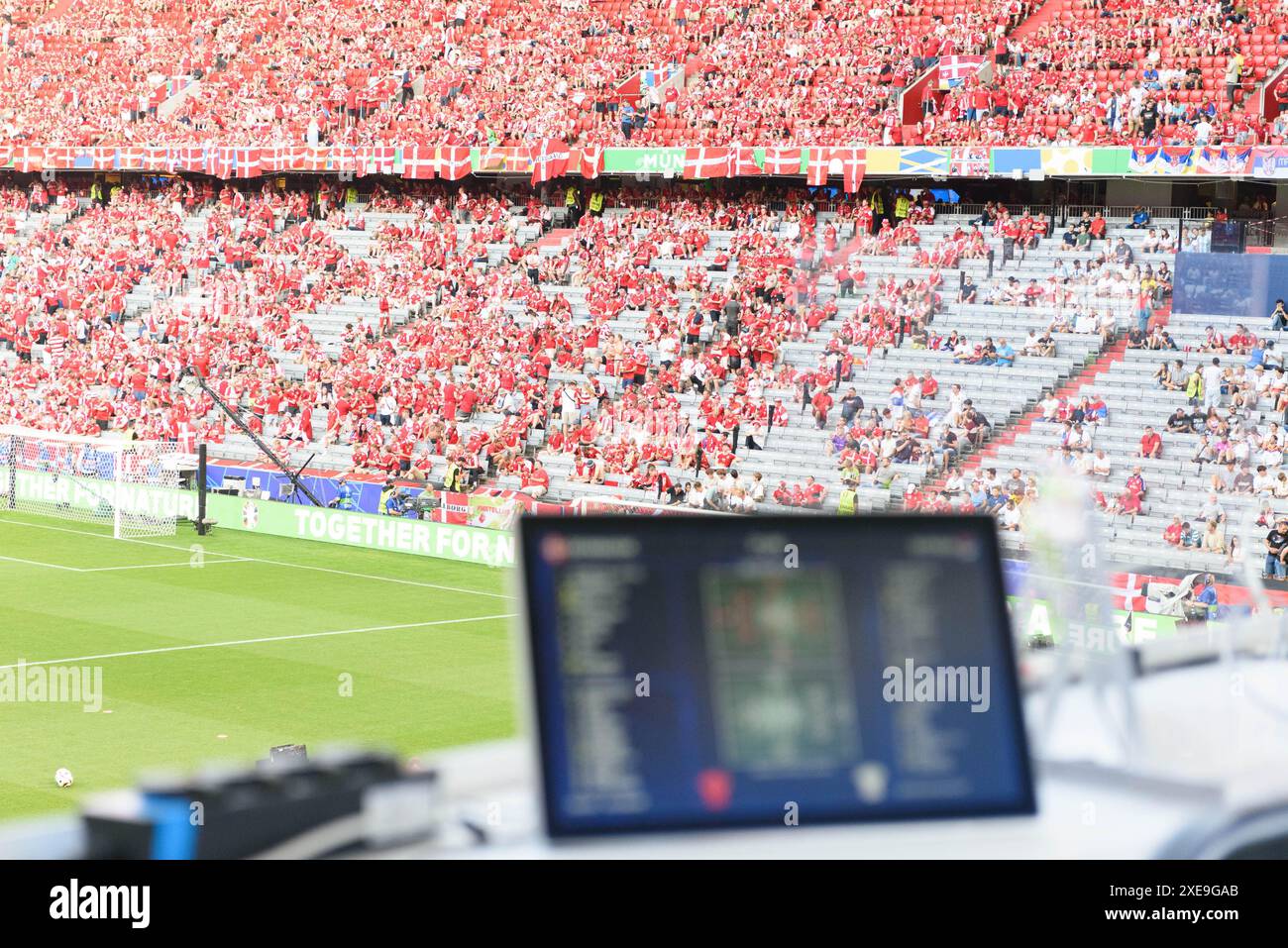 Monaco, Germania. 25 giugno 2024. Monaco di Baviera, Germania, 25 giugno 2024: Banco di lavoro mediatico sfocato nel forground con i tifosi della Danimarca sullo sfondo prima della partita di calcio UEFA EURO 2024 del gruppo C tra Danimarca e Serbia all'Arena Munich, Germania. (Sven Beyrich/SPP) credito: SPP Sport Press Photo. /Alamy Live News Foto Stock