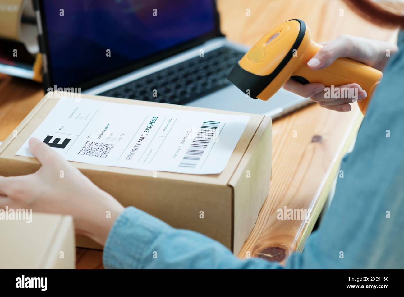Scansione del codice a barre sulla scatola di spedizione con scanner Foto Stock