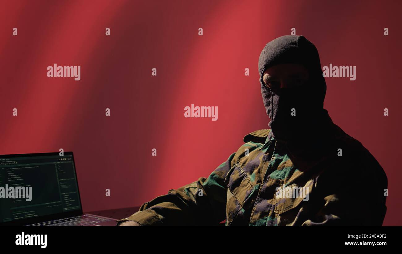 Agente di polizia segreta cinese che utilizza strumenti di propaganda di massa su laptop per influenzare le menti della popolazione, impegnandosi in operazioni psicologiche. Spia cinese che commette la guerra PsyOp usando il notebook, la fotocamera B. Foto Stock