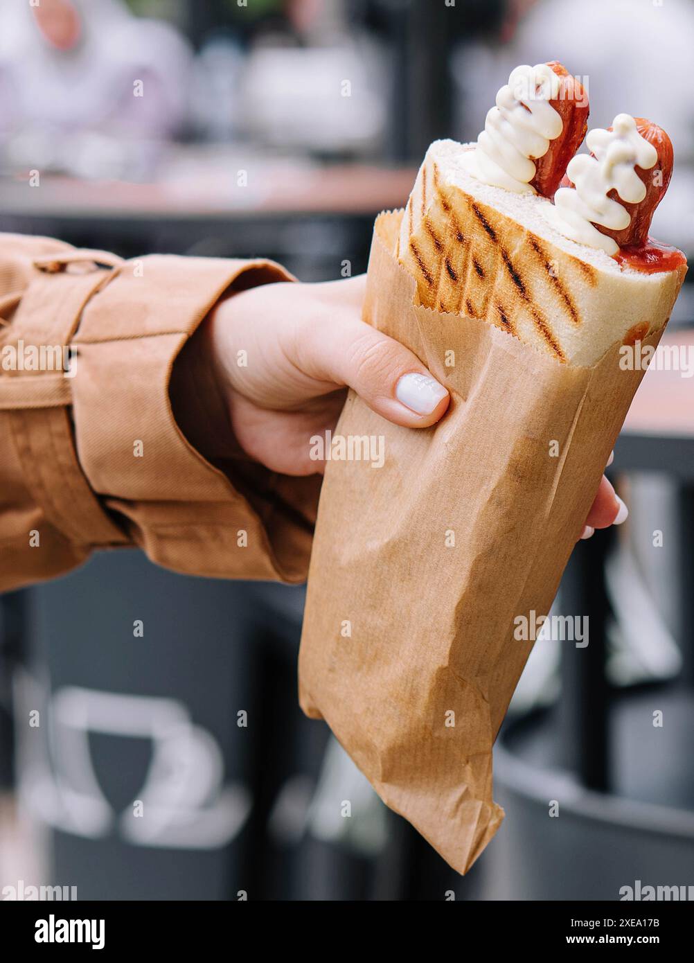 Hot dog francesi in mano alla donna Foto Stock