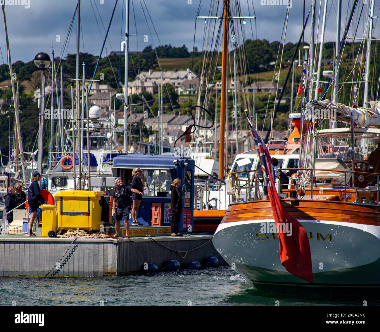 Vivace porticciolo con persone, barche e dettagli colorati, che catturano l'essenza di un vivace porto con una corda di ormeggio a mezz'aria a Falmouth in Cornovaglia Foto Stock