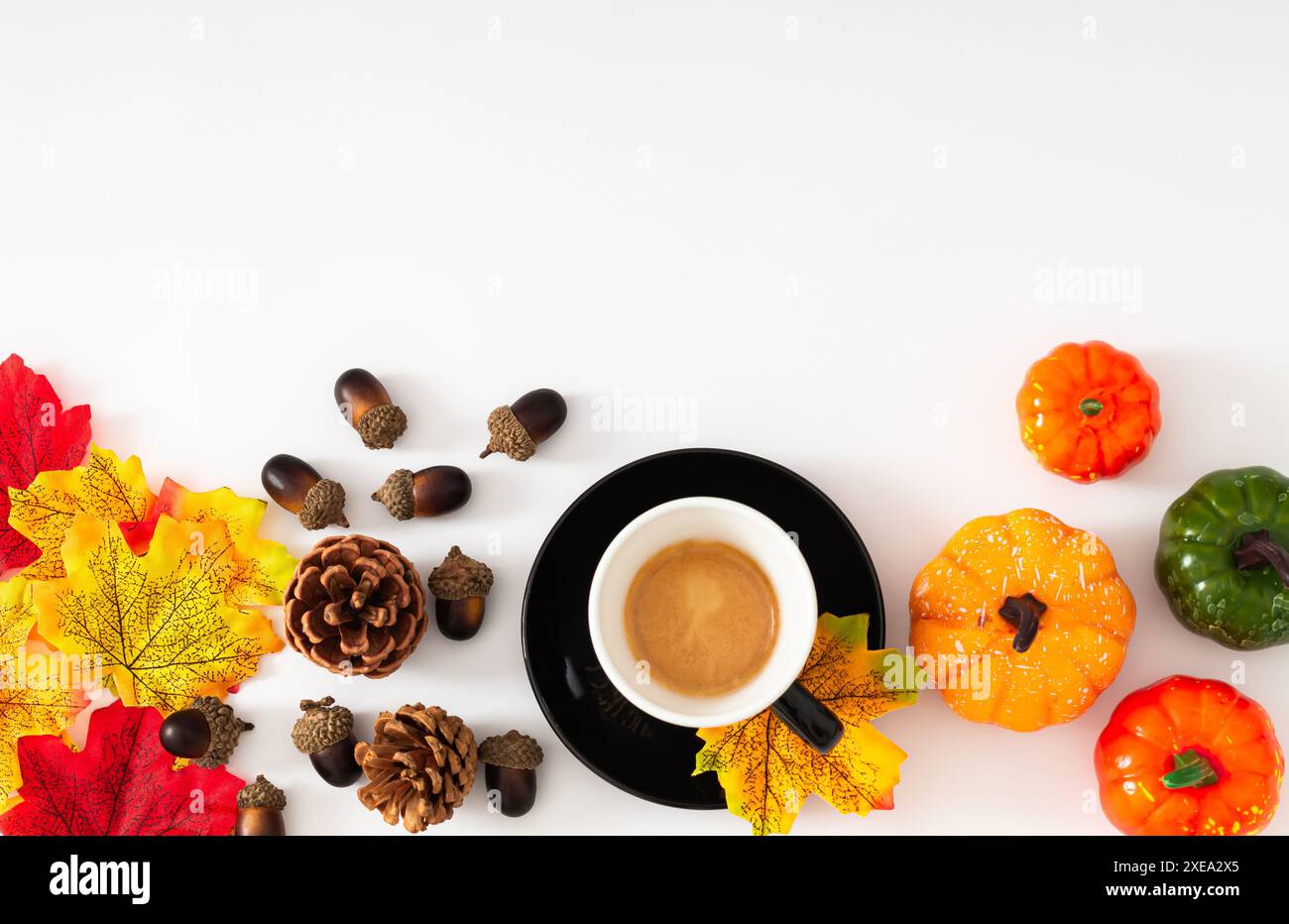 Scena autunnale o autunnale con tazza di caffè, foglie autunnali colorate, varie zucche, pinne e noci con spazio per copiare su sfondo bianco. Foto Stock