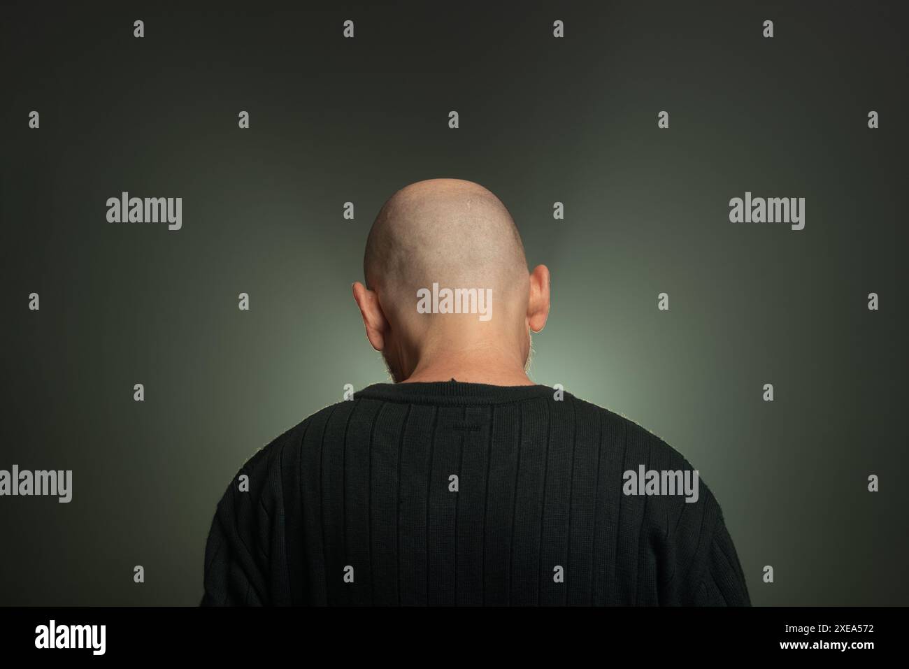 Misterioso uomo calvo di mezza età con una camicia scura. Foto in studio. Sfondo studio con fumo artificiale. Foto Stock