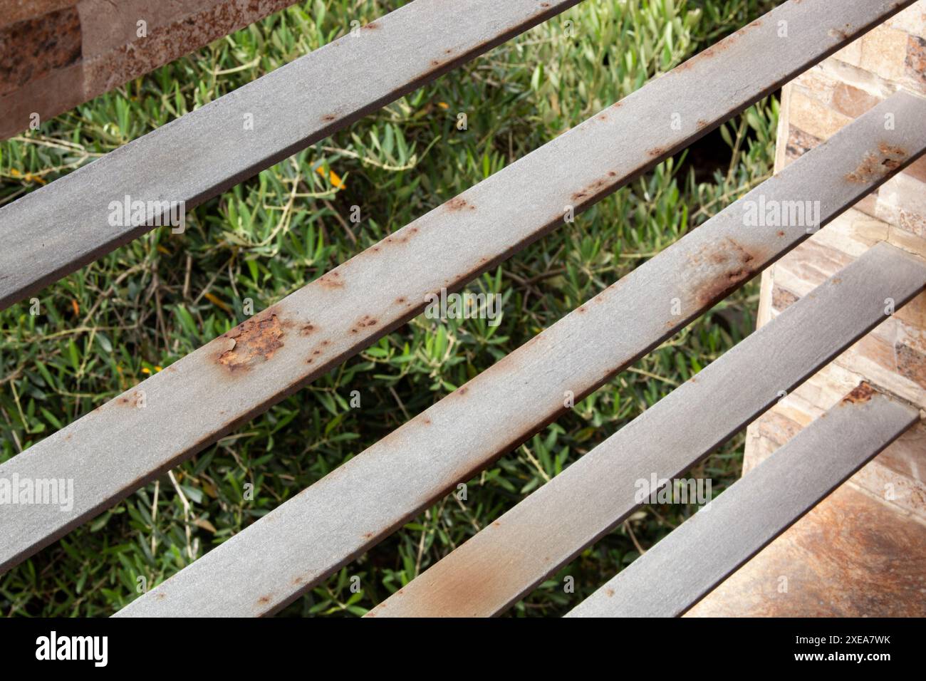 Ringhiera arrugginita su un balcone sullo sfondo di alberi. L'umidità corrode la gelatina. Sfondo orizzontale Foto Stock