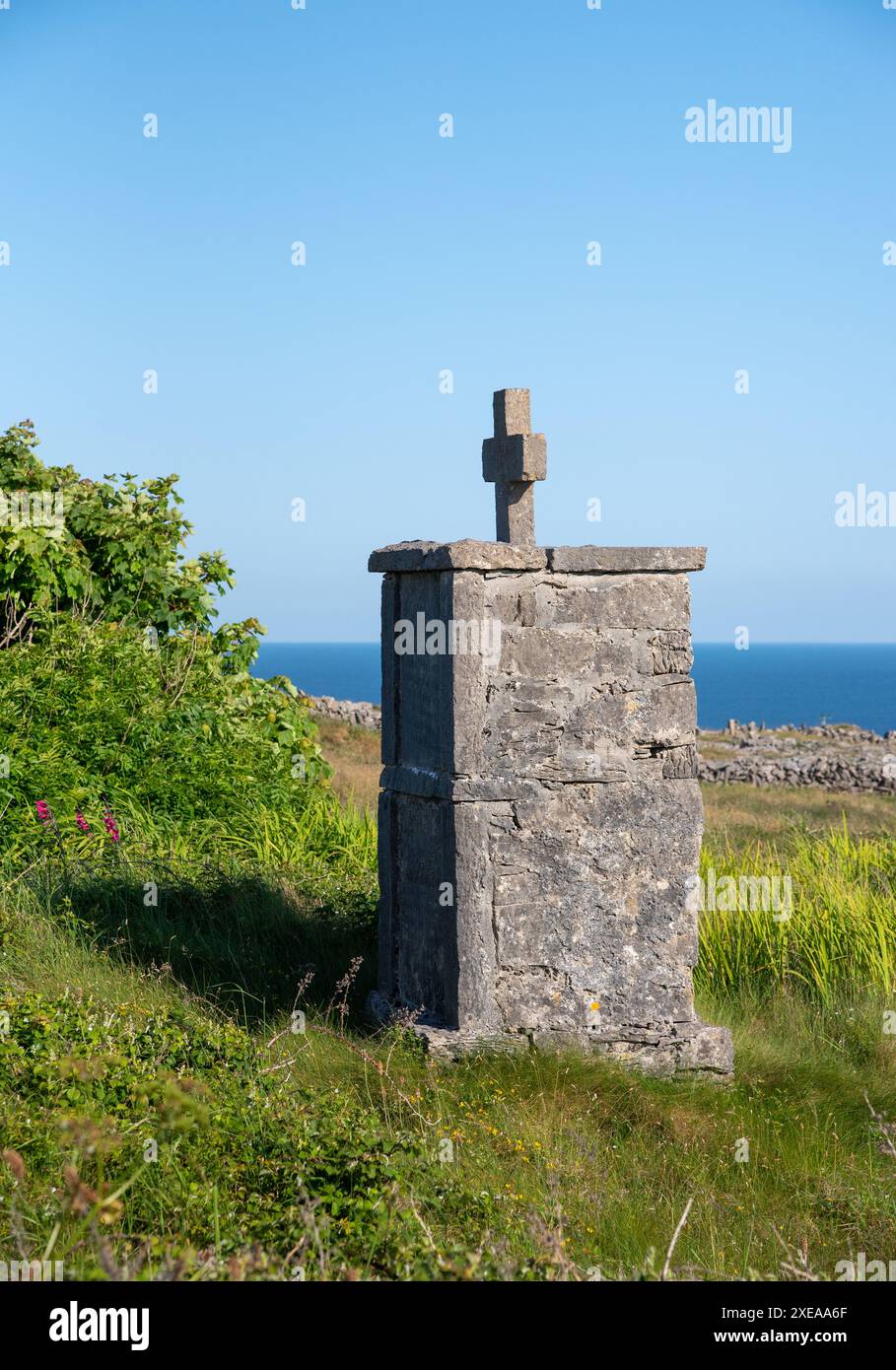 Tradizionale croce di sepoltura, situata lungo la strada nell'isola di Inishmore, nelle isole Aran, nella contea di Galway, sulla costa dell'Irlanda occidentale Foto Stock